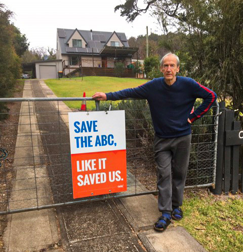 Image of Robert, an Eden-Monaro member, standing with his ABC Yard sign that reads "Save the ABC, like it saved us."